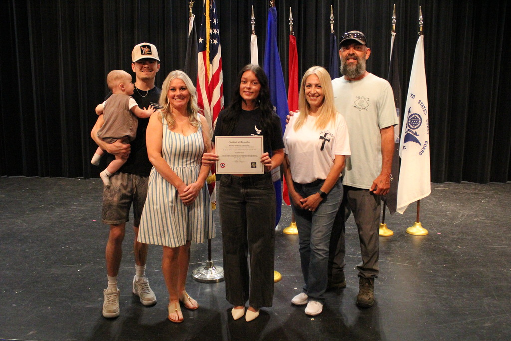 Isabella poses with her family after the signing ceremony.