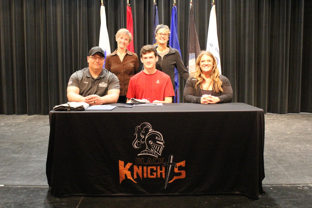 Caleb and his family members pose after Caleb signed his certificate.