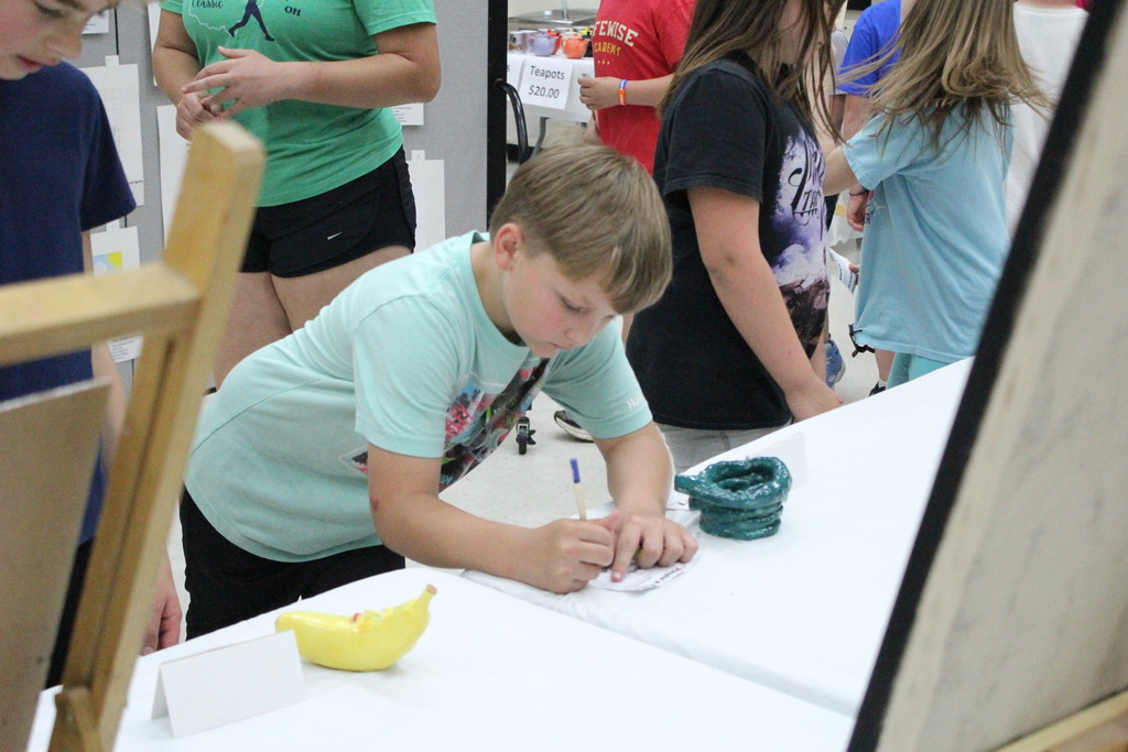 A student places his vote at the art show.