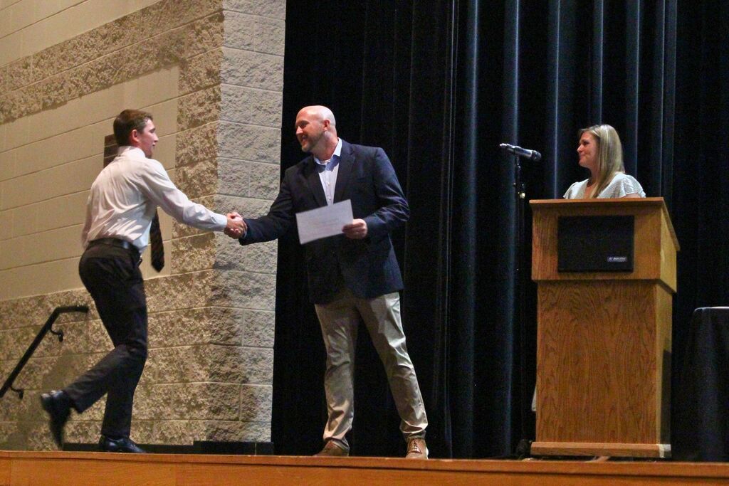 Brady shakes Mr. Shoup's hand after receiving an award.