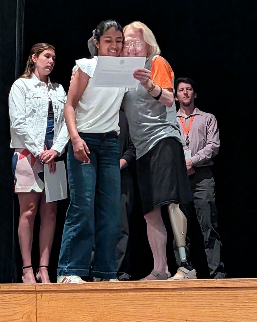 Mrs. Obenour congratulates a student at the Middle School Ceremony of Excellence.