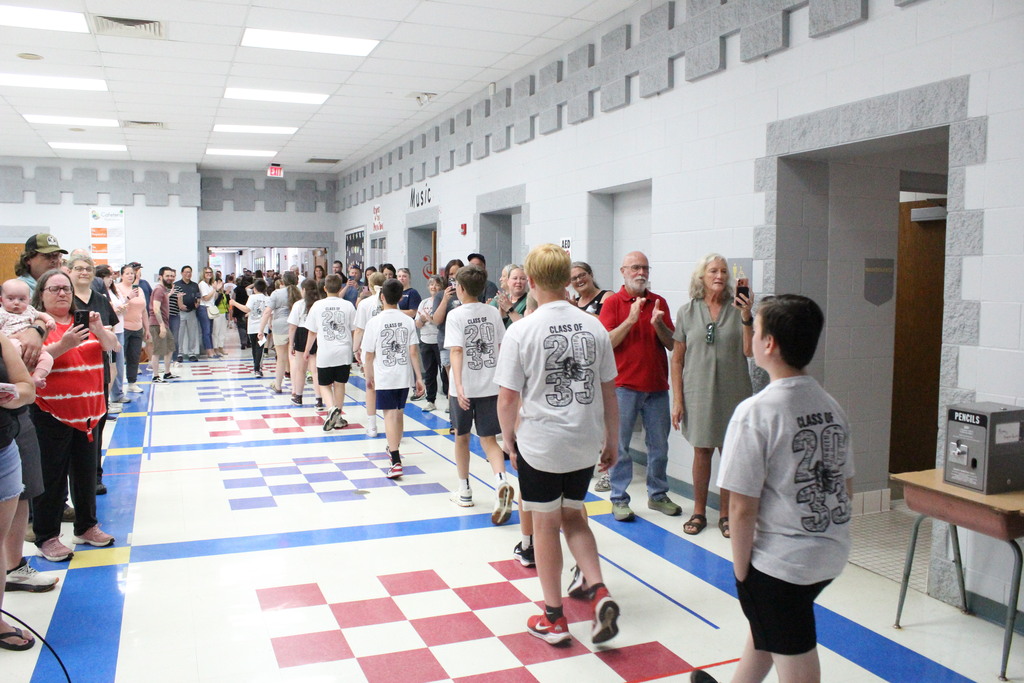 Fifth grade students are clapped out of the elementary as they pass through the cafeteria.