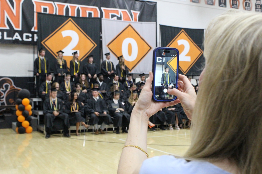 A parent takes a picture of her son after he had received his diploma.
