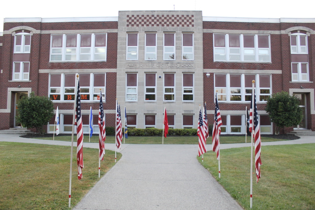 Flags are displayed in front of the middle school building.