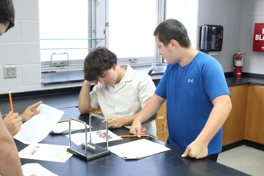 A picture of two students working through a lab on the first day of physical science.