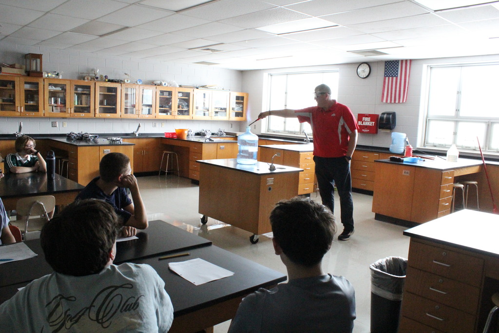 A picture showing Mr. Schumaker showing the flammability of a substance.