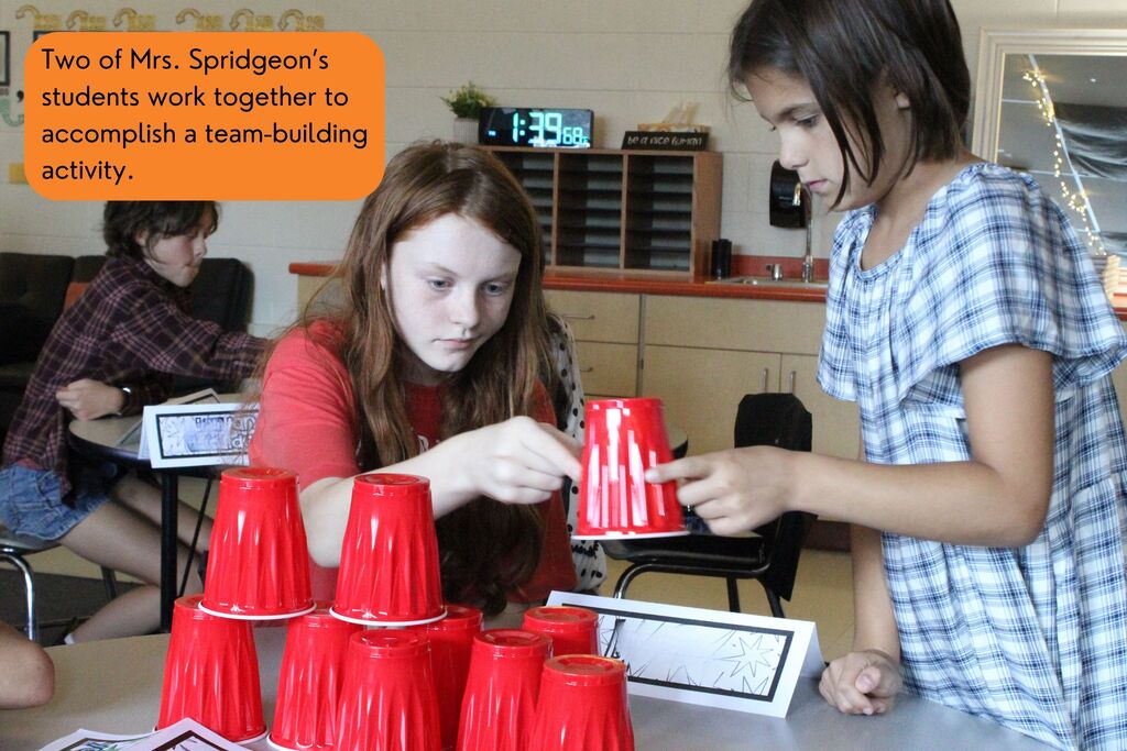 A picture showing two of Mrs. Spridgeon's students working together to accomplish a team-building activity.