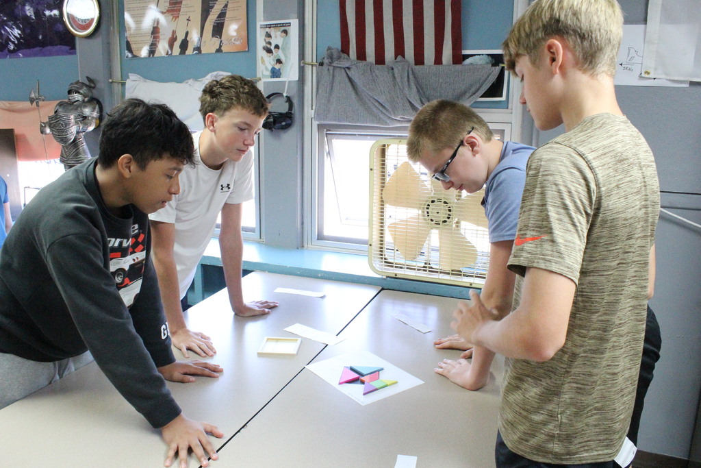 A picture of middle school students working together to solve a puzzle on Welcome Back Day.