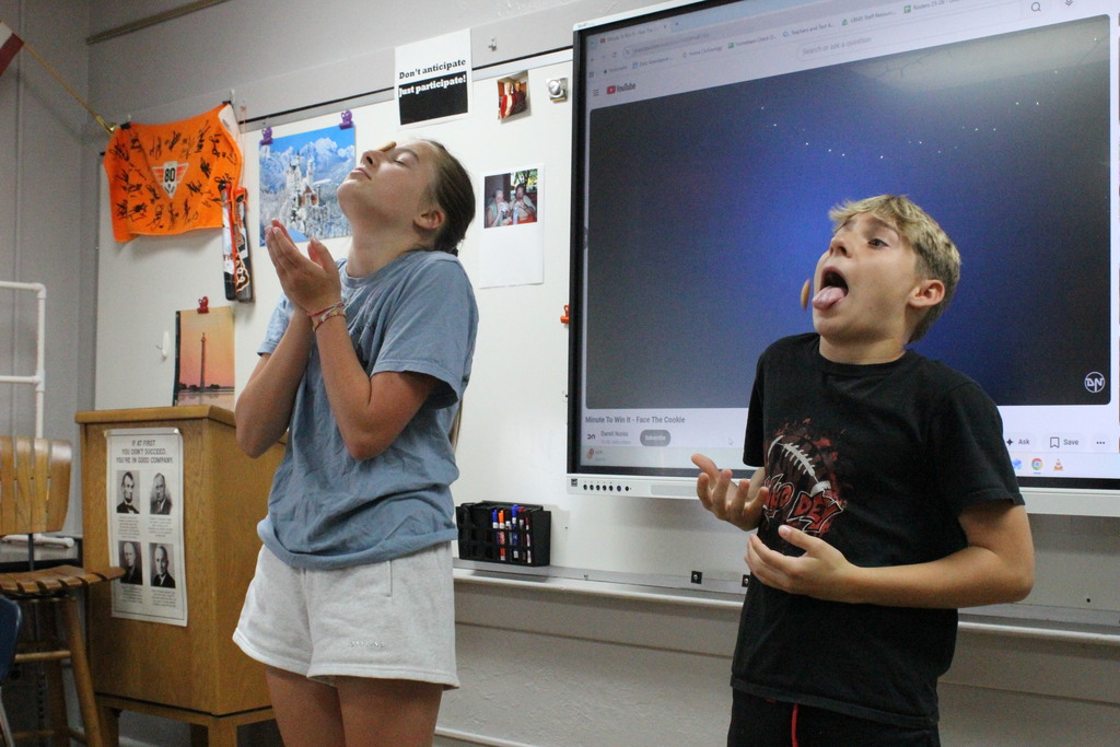 A picture of students participating in the "Face the Cookie" Minute-to-Win-It game on Welcome Back Day.