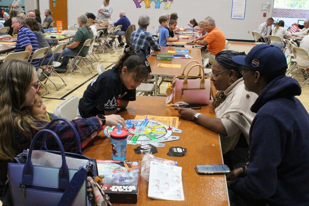 A student and her VIPs play the game Sorry.