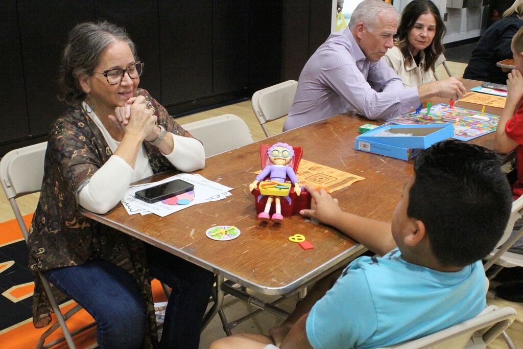 A picture of a student and VIP playing a game involving a grandma sitting in a chair.