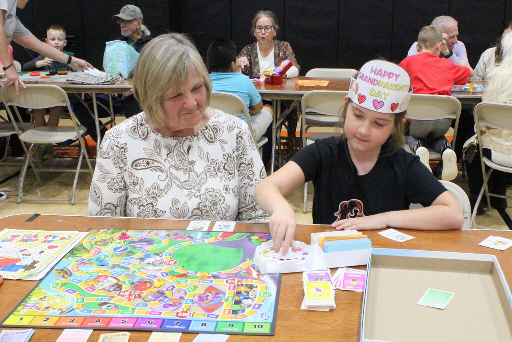 A picture of a student and VIP playing the game Life.