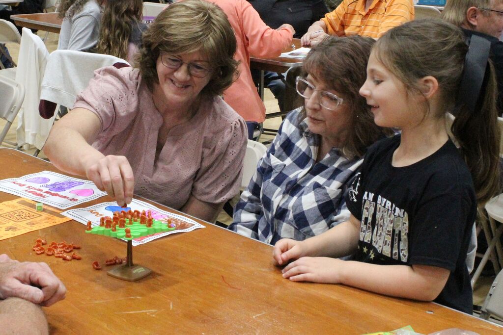 A picture of a student and two of her VIPs playing a balancing game.
