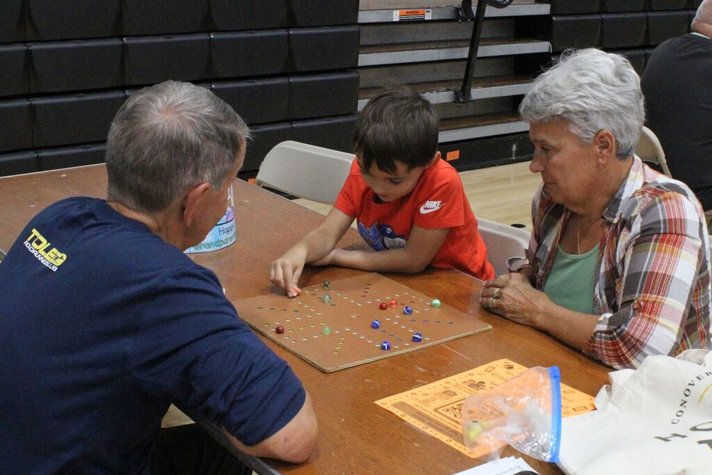 A picture of a student and his two VIPs playing an alternate form of checkers.