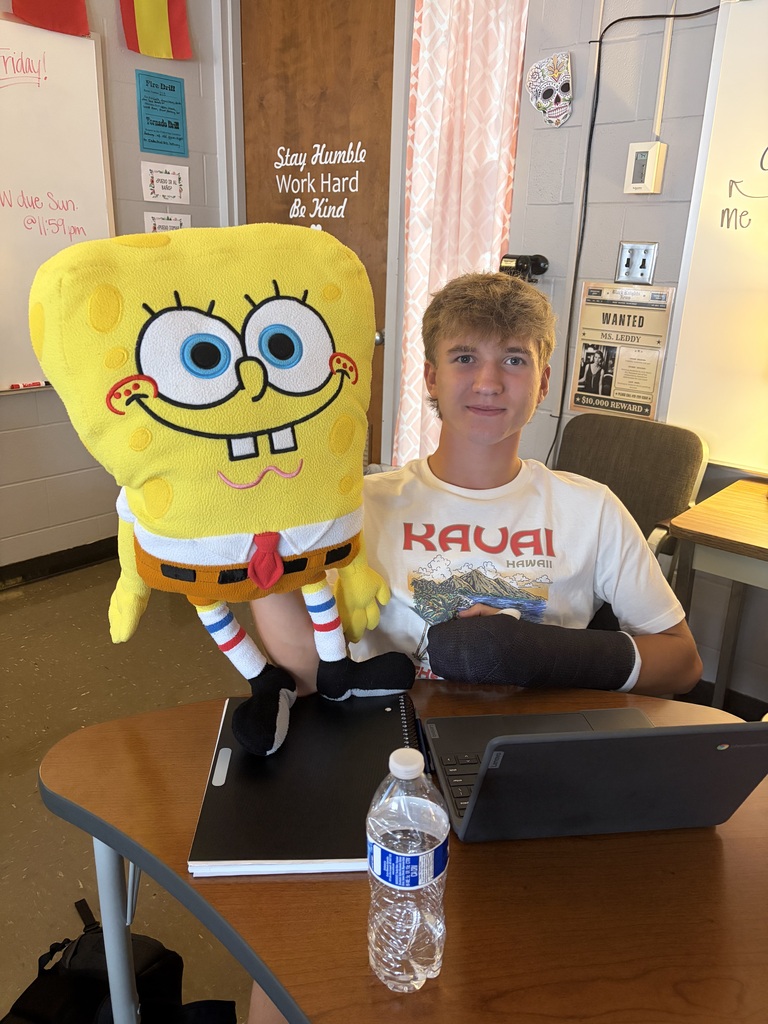 A picture of a CCP Spanish III student posing with a Spongebob Squarepants stuffed creature.