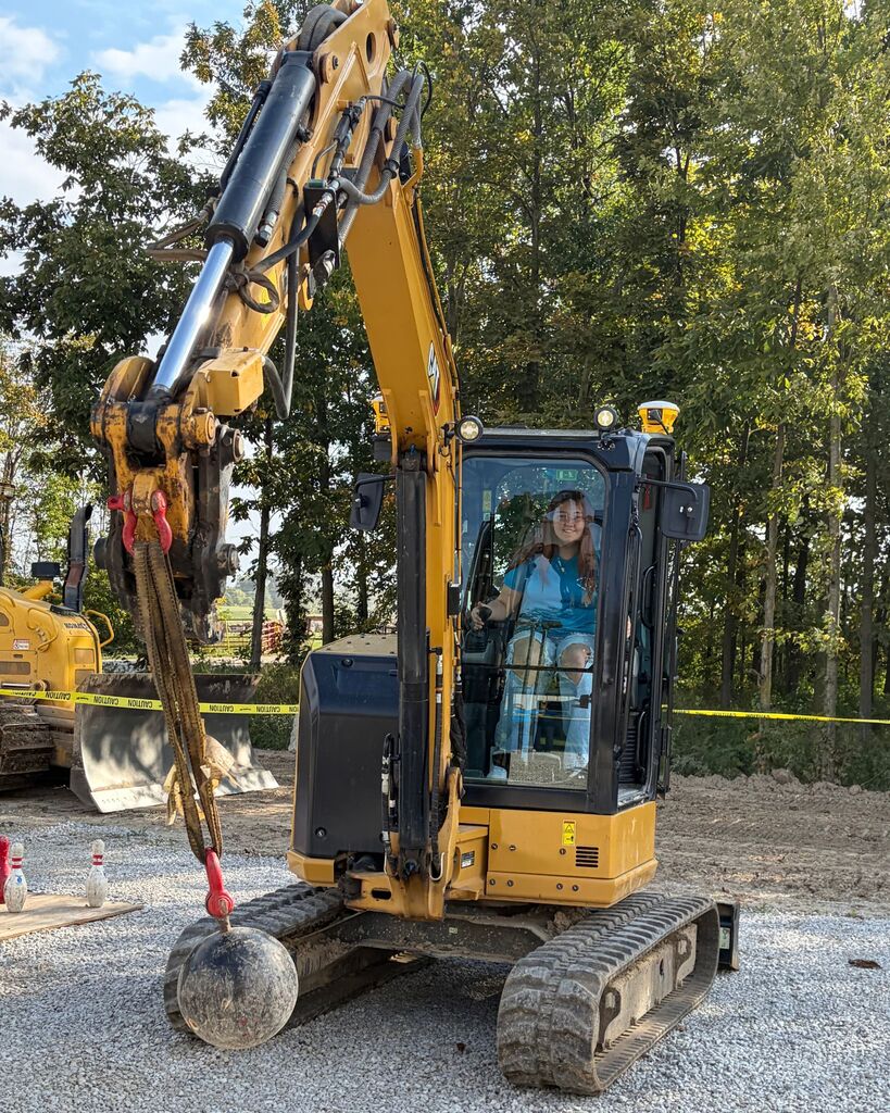 A picture of a student running equipment to swing a wrecking ball.