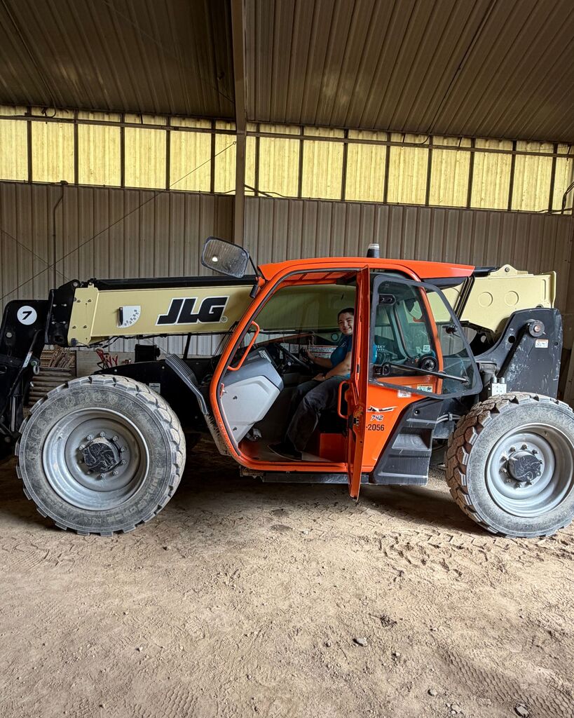 A picture of a student driving a forklift.