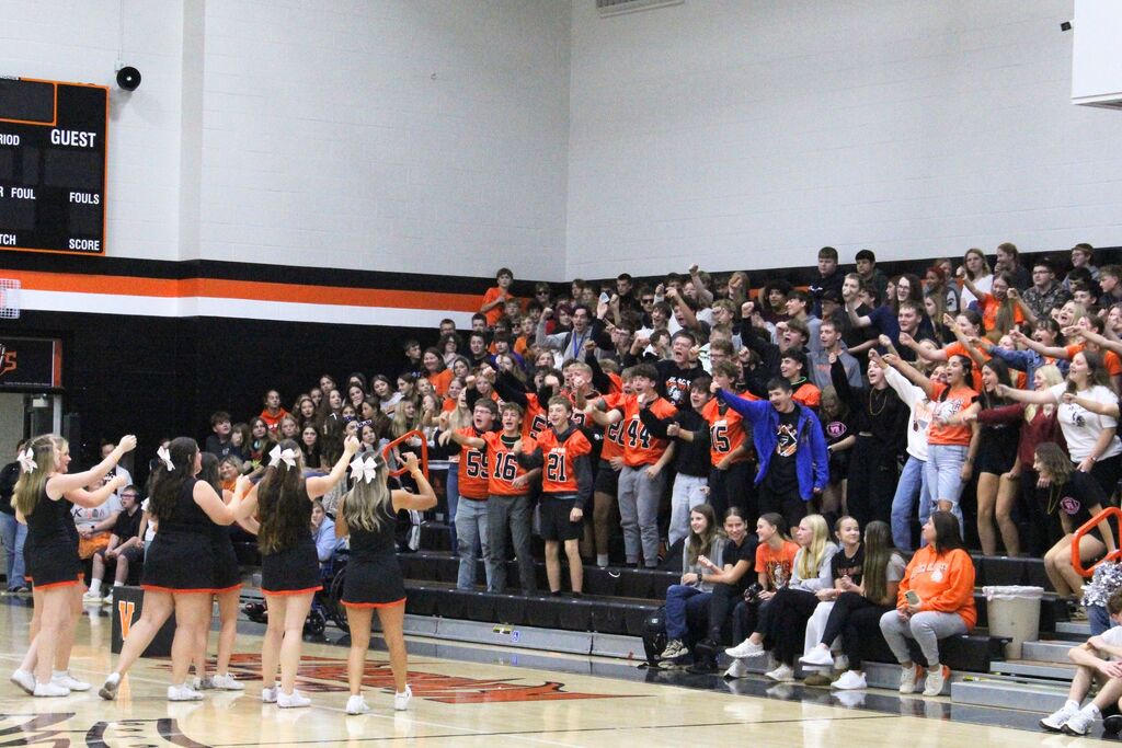 A picture of the cheerleaders leading the juniors in a cheer.