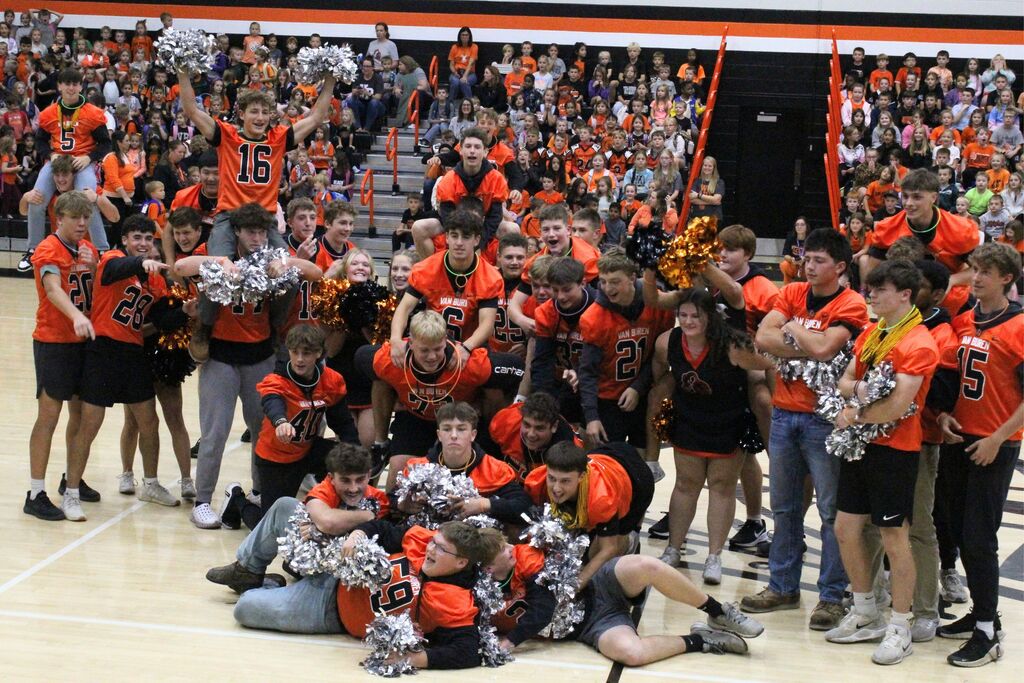 The football team gathers for a picture at the conclusion of their routine with the cheerleaders.