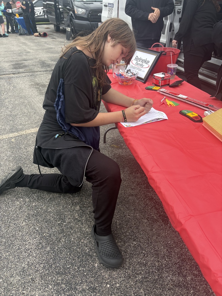 A picture of a student filling out his event paperwork at the Reineke Family Dealerships table.