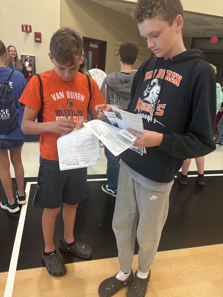 A picture of students completing their paperwork for the event to have the opportunity to win door prizes.