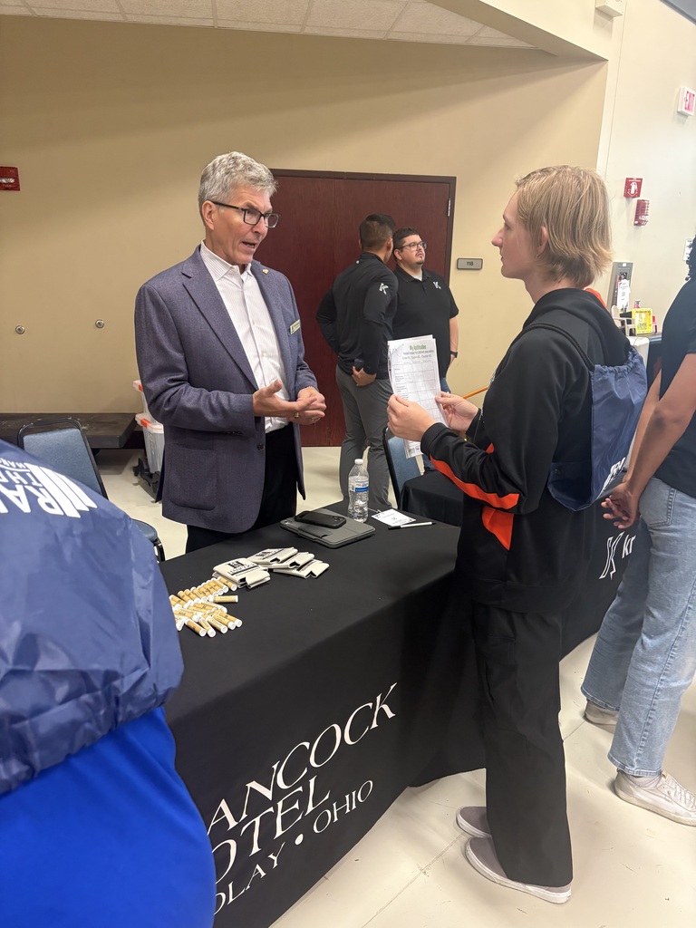 A picture of a student talking to a representative of the Hancock Hotel about career opportunities.