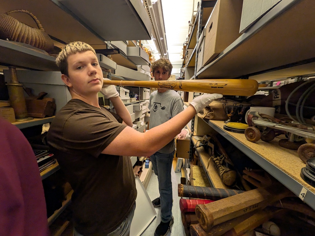 Wearing white gloves to protect the artifacts, a student had the opportunity to hold a baseball bat signed by Hancock County native Forest "Tot" Pressnell, who played in the major leagues from 1938-1942.