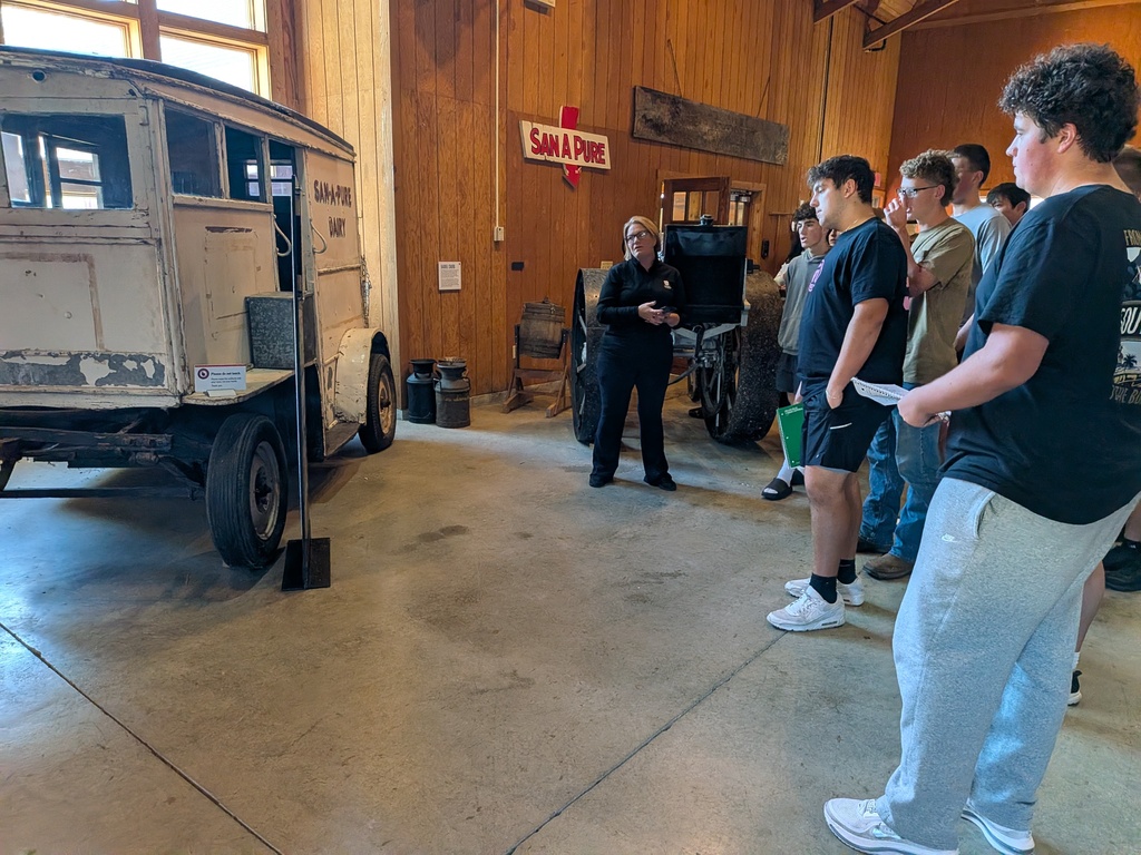 Students learn about a wagon that was once used to transport milk across Hancock County.