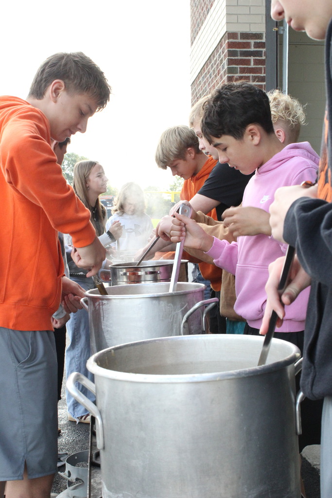 A picture of middle school students helping cook the apples.