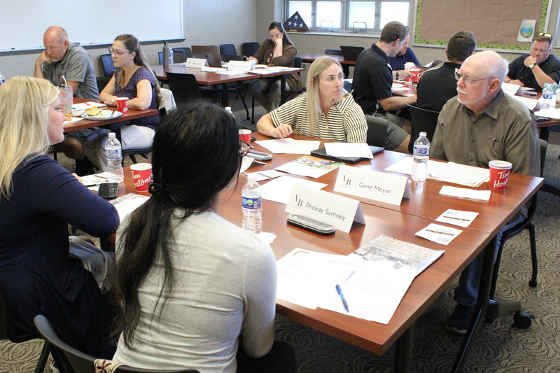 Strategic Plan Advisory Team members Jenn Barrett, Phoxay Sumney, Abby Allen, and Gene Meyer discuss the information shared with them and prepare to offer feedback.