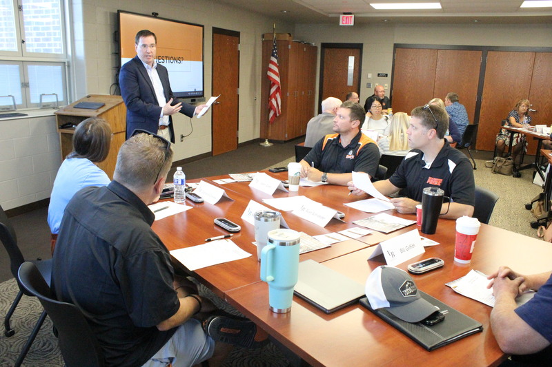 Superintendent Dr. Jason Inkrott meets with a table to discuss their ideas.