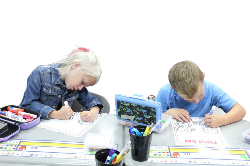 Elementary students color on the first day of school