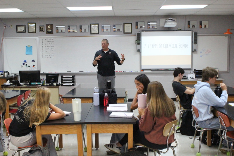 Mr. Adam Schumaker explains an AP Chemistry concept to students