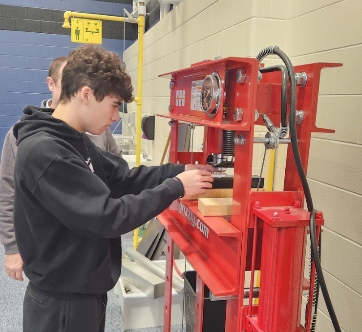 A student presses a bearing into a 3D printed gear.