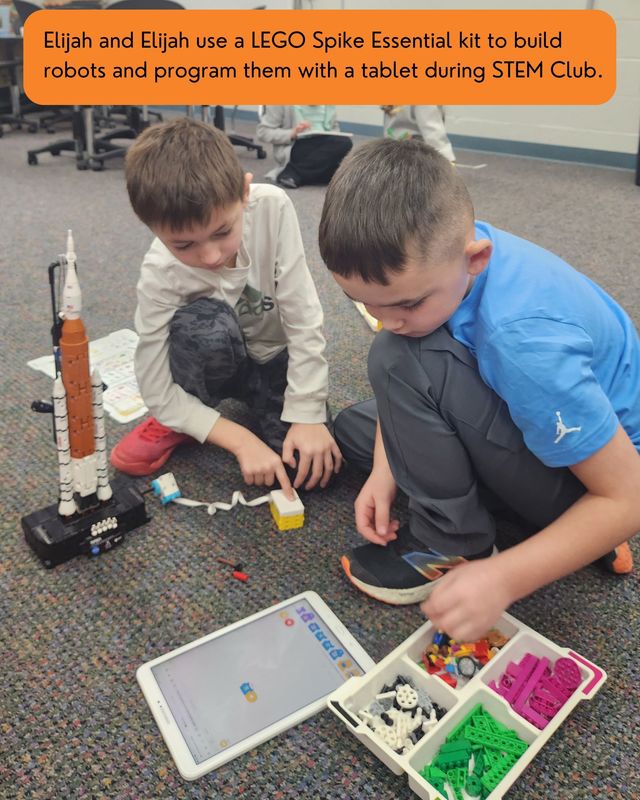 Elijah and Elijah use a LEGO Spike Essential kit to build robots and program them with a tablet during STEM Club.
