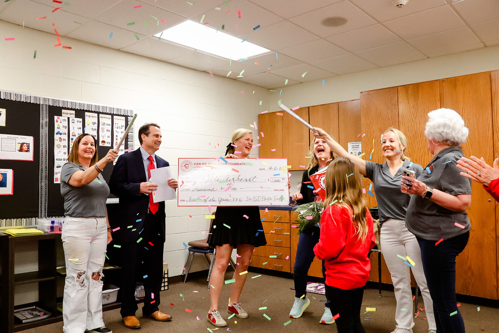Confetti falls as Mrs. Airheart is excited to receive a check