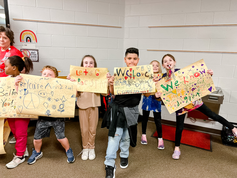 Students holding up encouraging signs