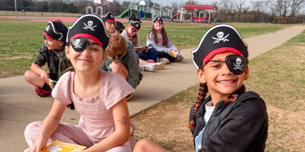 students outside reading with pirate hats and eyepatches on