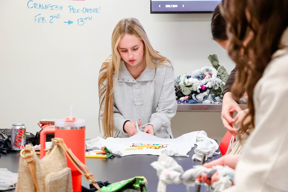 student cutting up tshirt