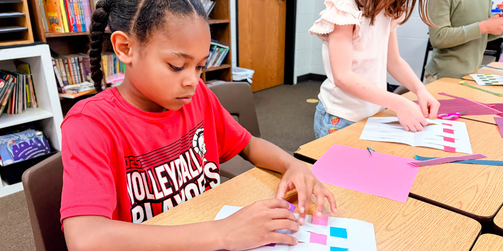 student working on a basket weaving project at her desk