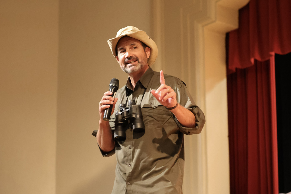 Male speaker on stage in a safari hat