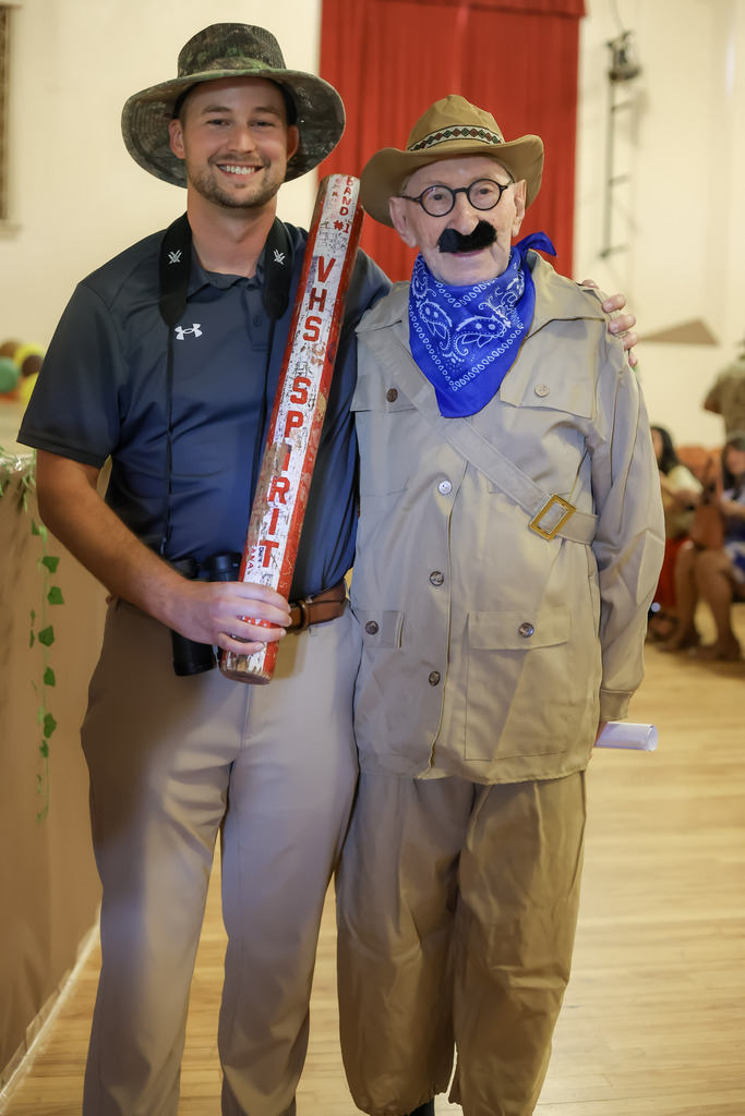 Two men in safari costumes holding a spirit stick