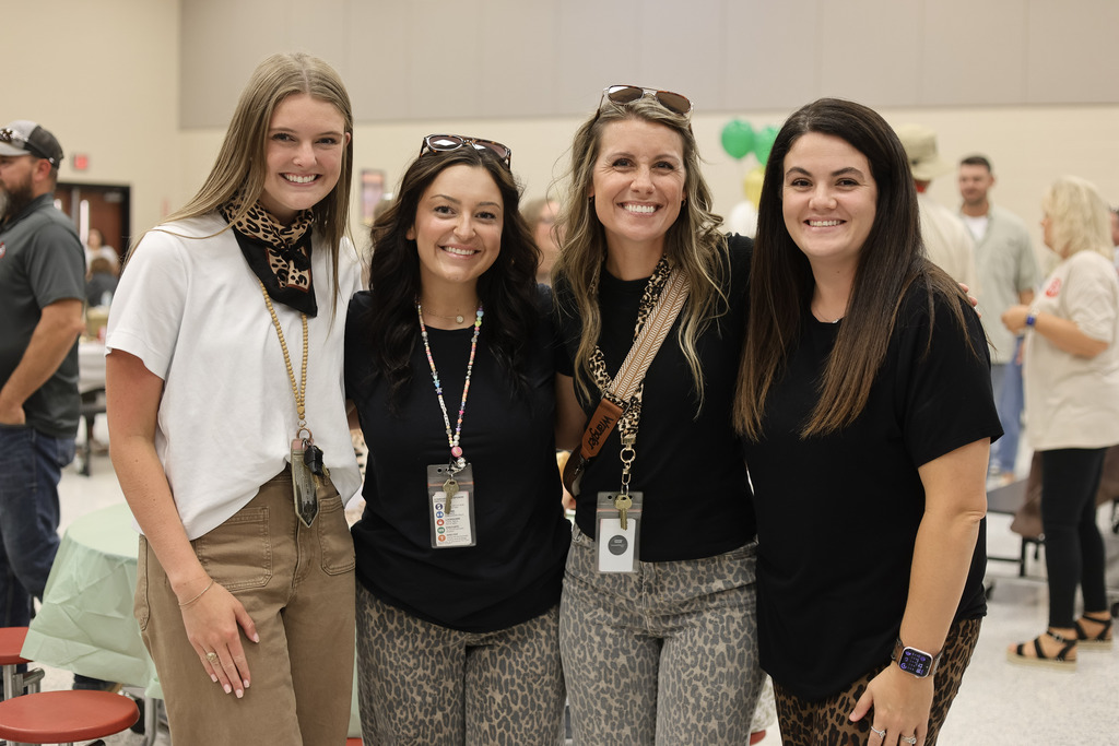 Four women standing in a cafeteria