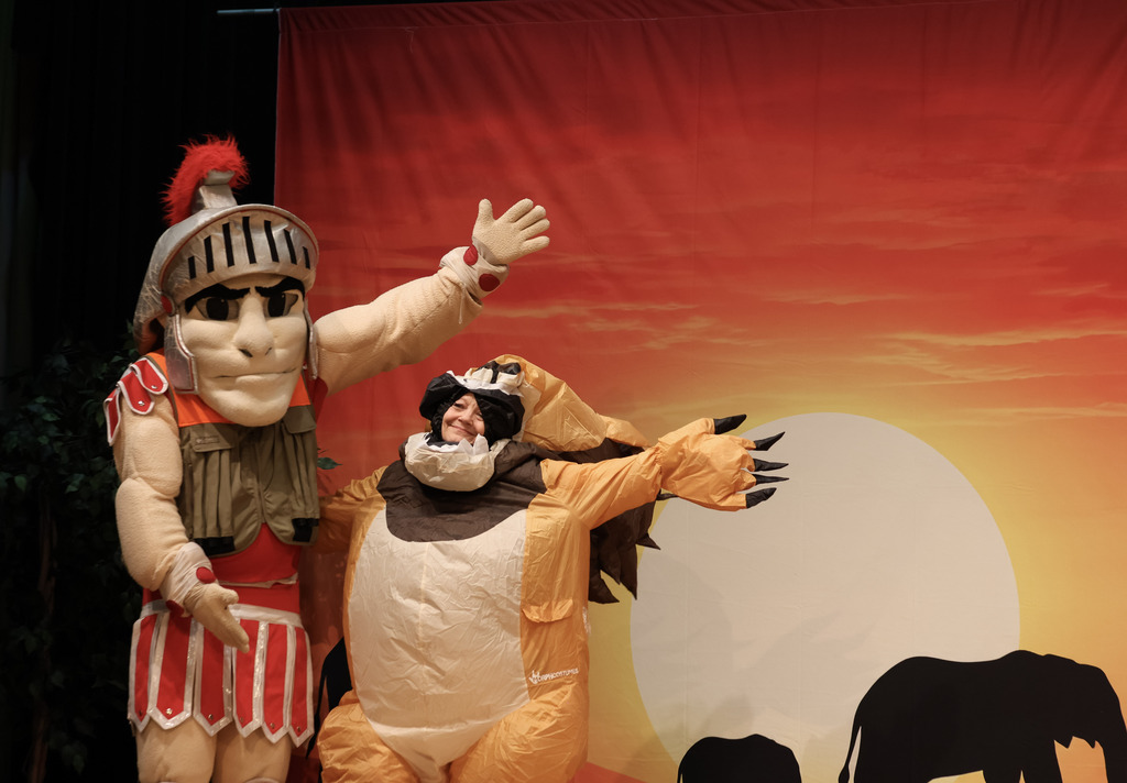 Mascot and a woman in costume on stage