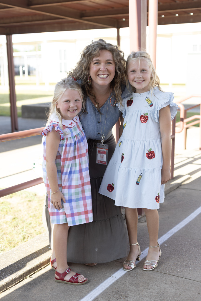 Woman and two girls smiling at the camera