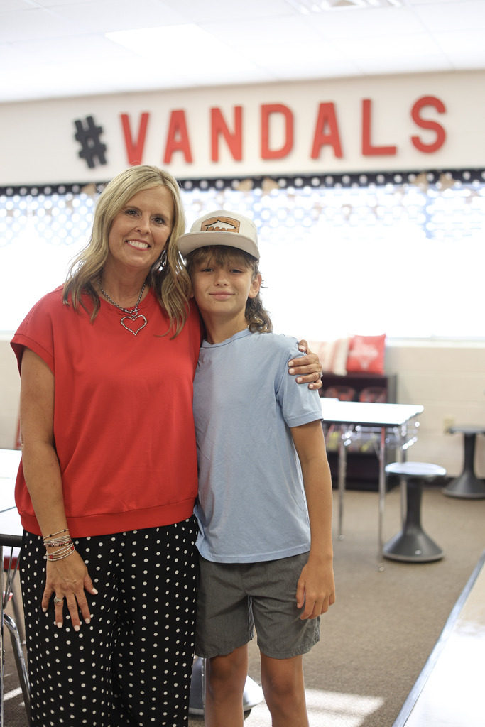 Teacher and student smiling at the camera in a classroom