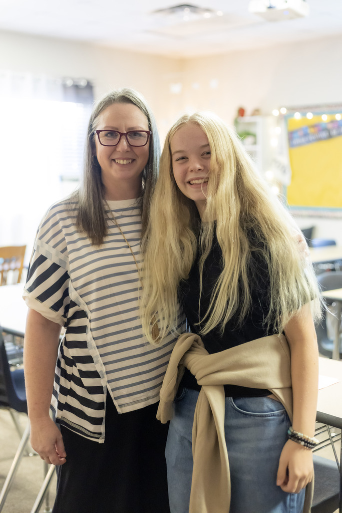 Teacher and a student standing together in a classroom