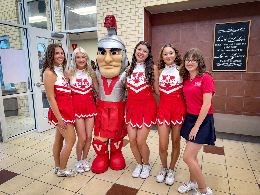 cheerleaders + mascot in a school hallway