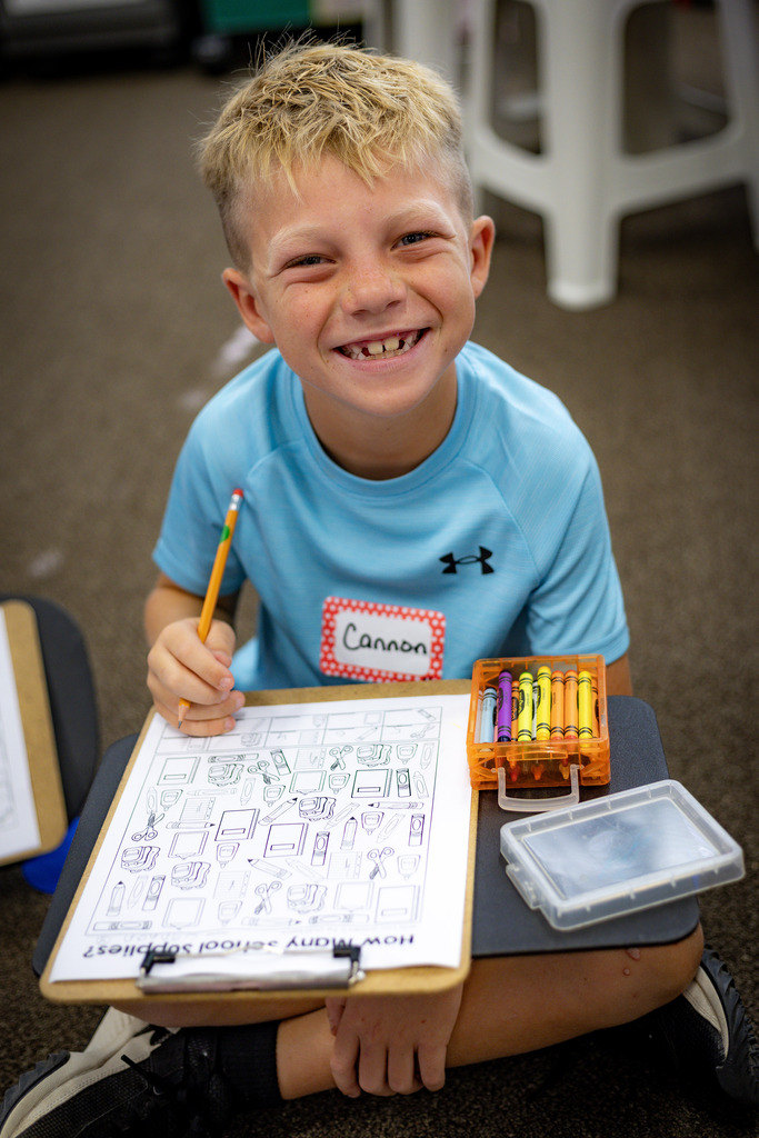 boy working at a floor desk