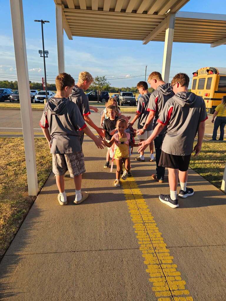 High school students welcoming elementary students to school